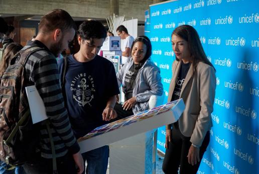 Jóvenes universitarios interactúan con personal de Naciones Unidas en una feria.