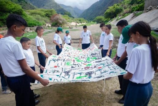 Un grupo de adolescentes sostienen una pancarta.