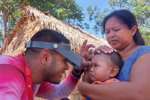 Personal médico realiza chequeo a un bebé sujetado por su madre.