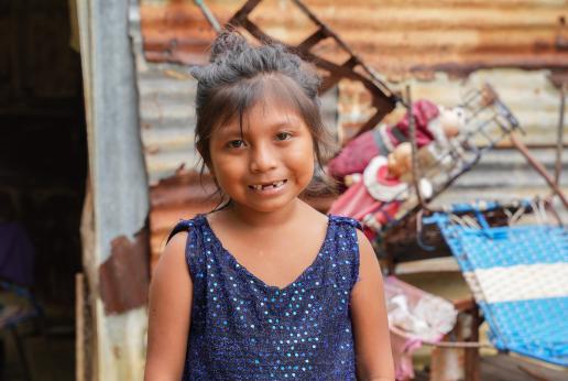 Una niña sonríe a cámara.