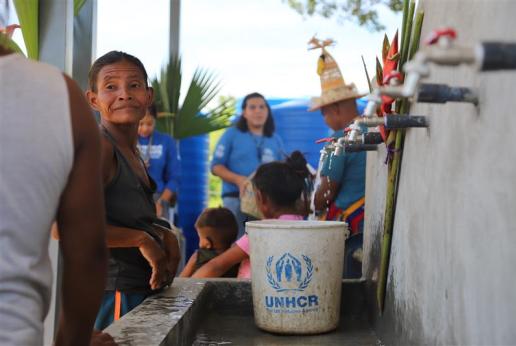 Mujer llena un tobo de agua potable. 