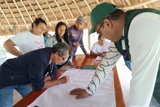 Un grupo de personas reunidas sobre un mapa.