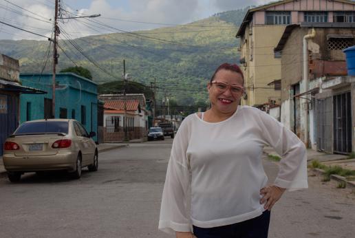 Una mujer sonríe a cámara en medio de una calle.