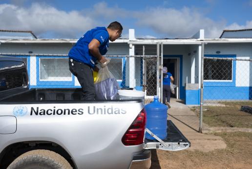 Un hombre descarga material de un vehículo de Naciones Unidas.