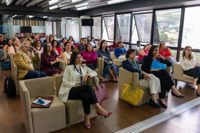 Personas sentadas en una sala de reunión.